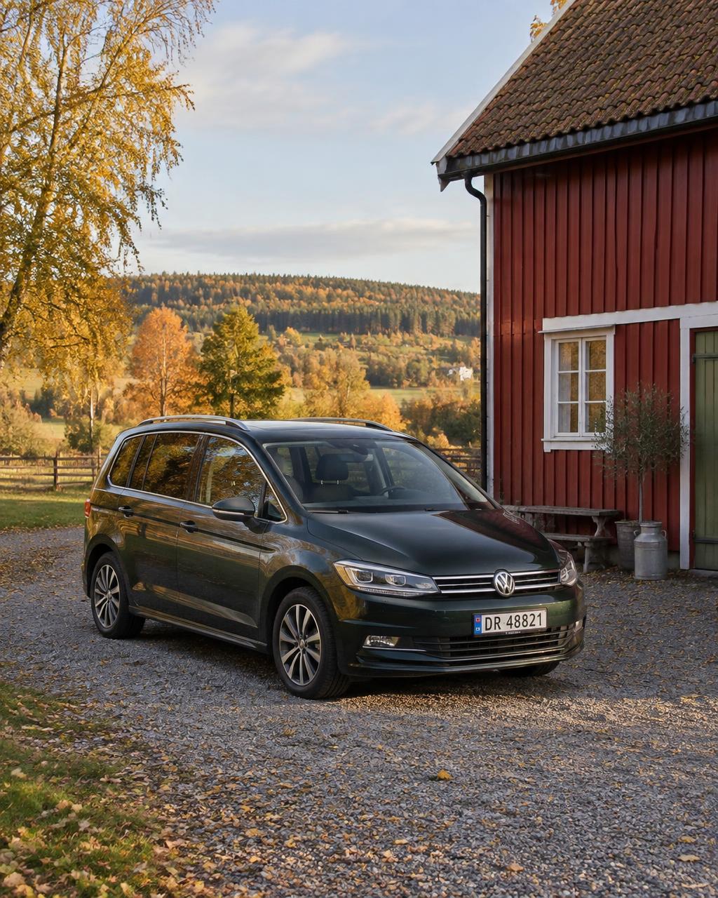Romslig familiebil foran rød låve i Vestfold